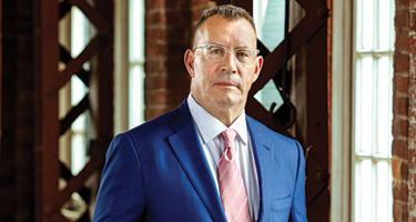 Suited man with glasses poses for professional headshot