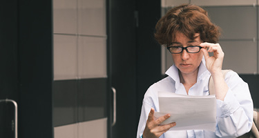 Woman with glasses reading a document
