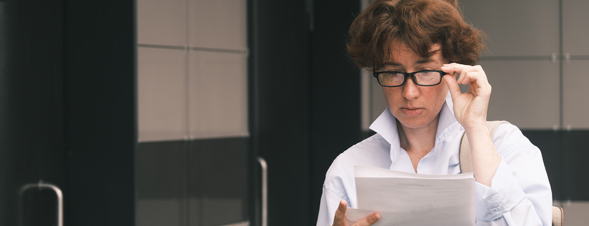 Woman with glasses reading a document