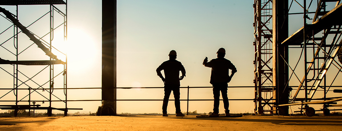 Two figures standing in construction site