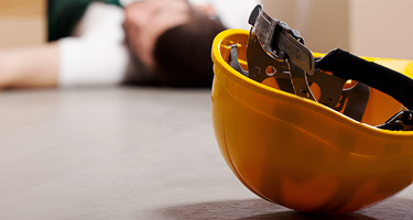 Hard hat on the floor with person in the background