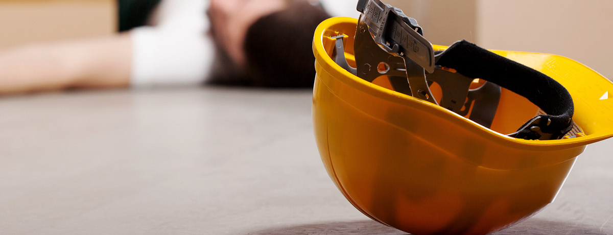 Hard hat on the floor with person in the background