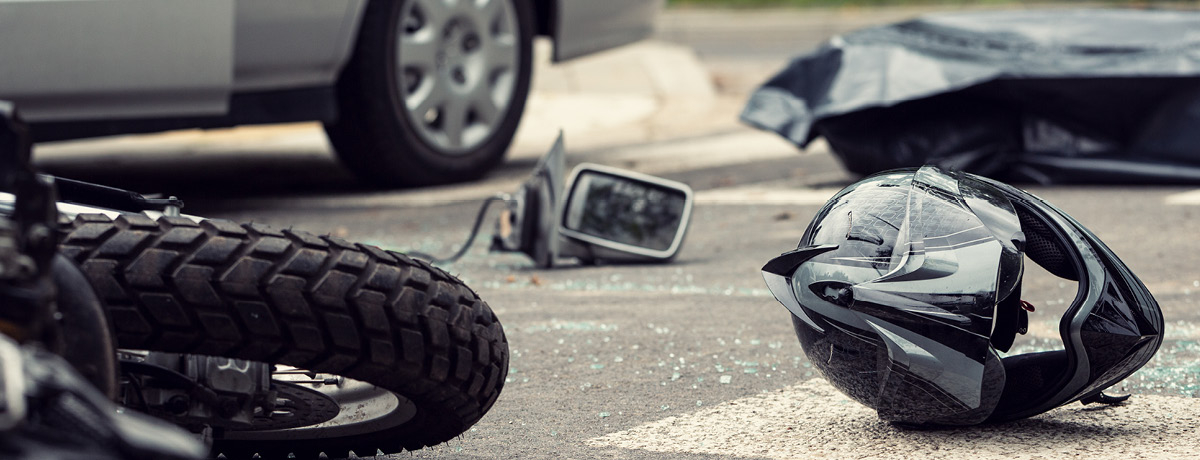 Motorcycle and helmet on ground after an accident