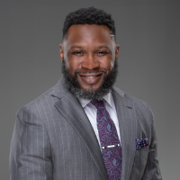 Lawyer with a suit and purple tie posing for headshot