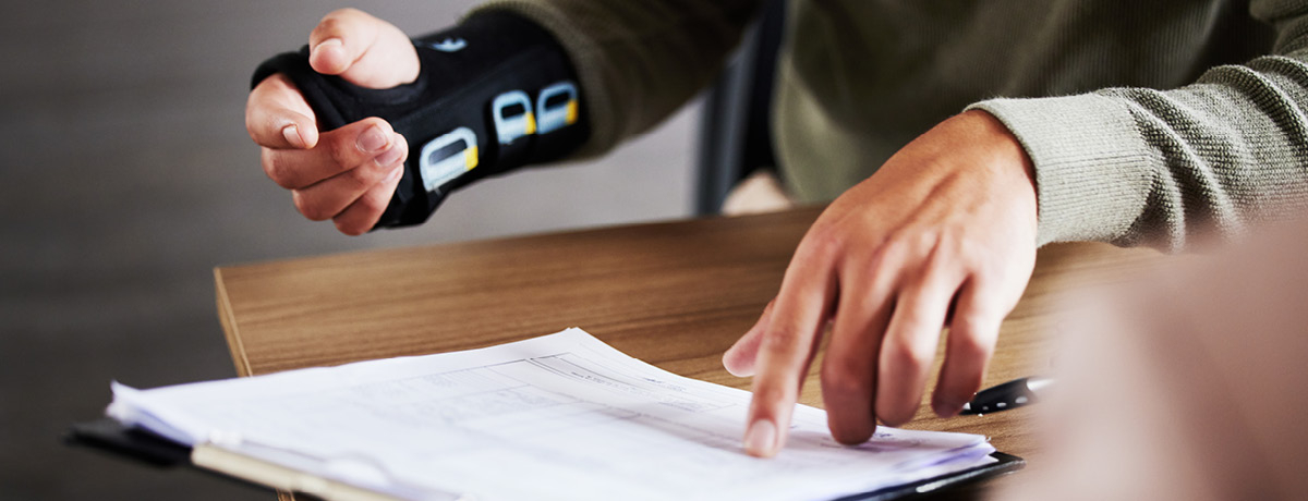 Unseen individual with hand brace points to a legal contract