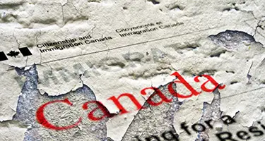 A close-up photograph showing a weathered and peeling document surface.