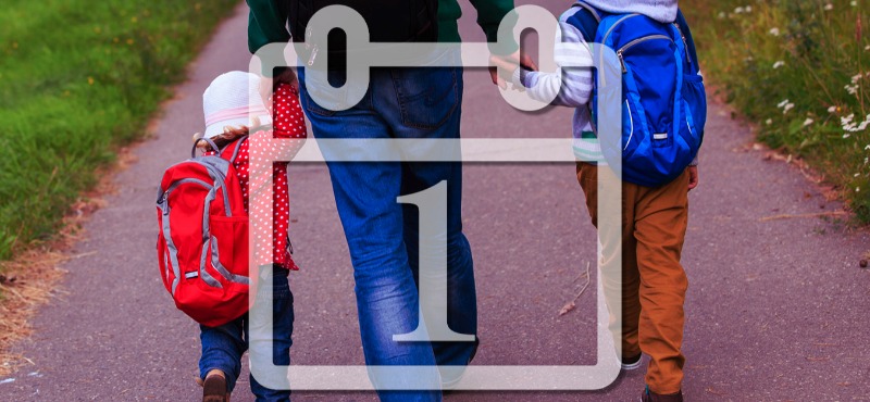 Father walks daughter and son down the road behind a calendar set for July 1st 
