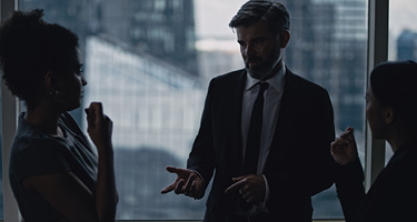 Two female and one male lawyer in suits having discussion