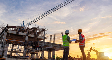 Two construction workers in PPE at construction site