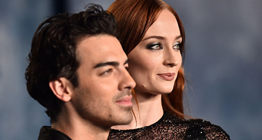 Man and woman celebrities wearing black and standing for photo