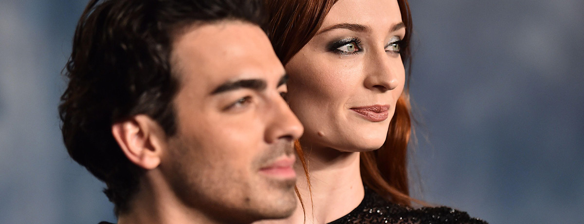 Man and woman celebrities wearing black and standing for photo