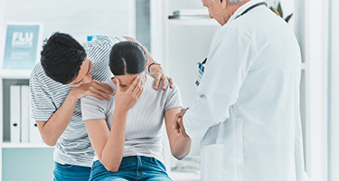Doctor consoles couple in medical office