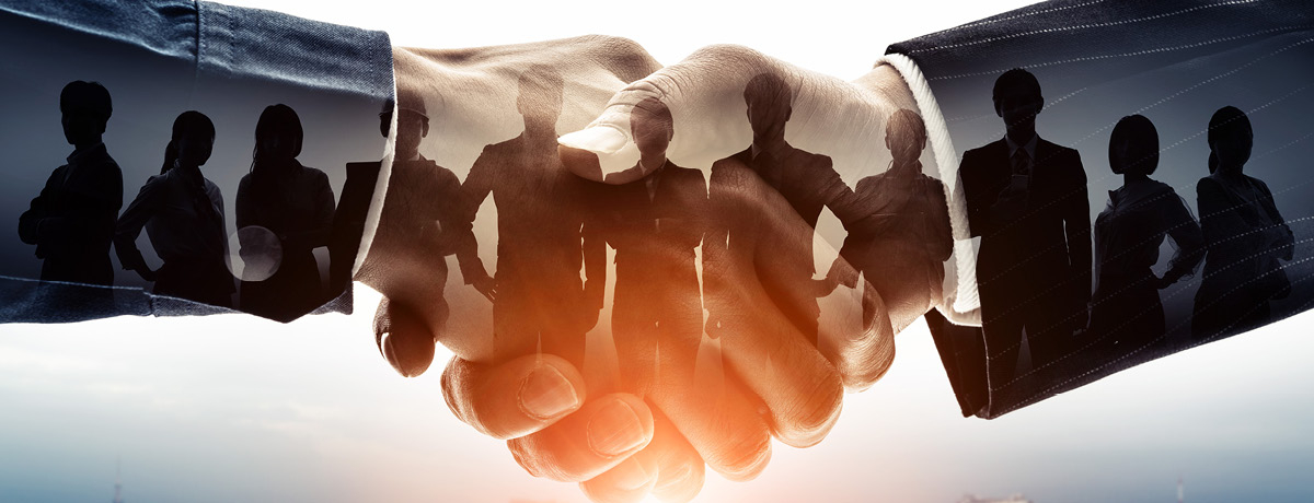 Hands shaking with silhouette of professionals