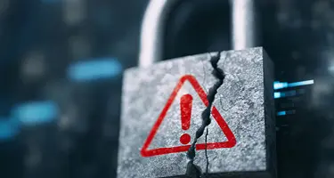 A close-up photograph of a weathered, grey metallic padlock that is cracked down the middle.