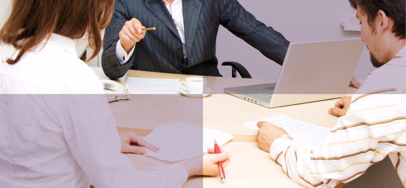 Boardroom with three attorneys sitting at a table in suits