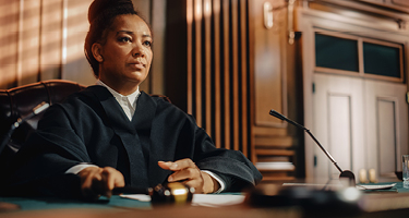 Judge sitting at the bench presiding over court case