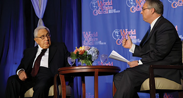 Two men sitting on stage talking
