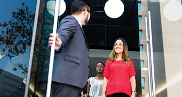 Three people leaving a conference room