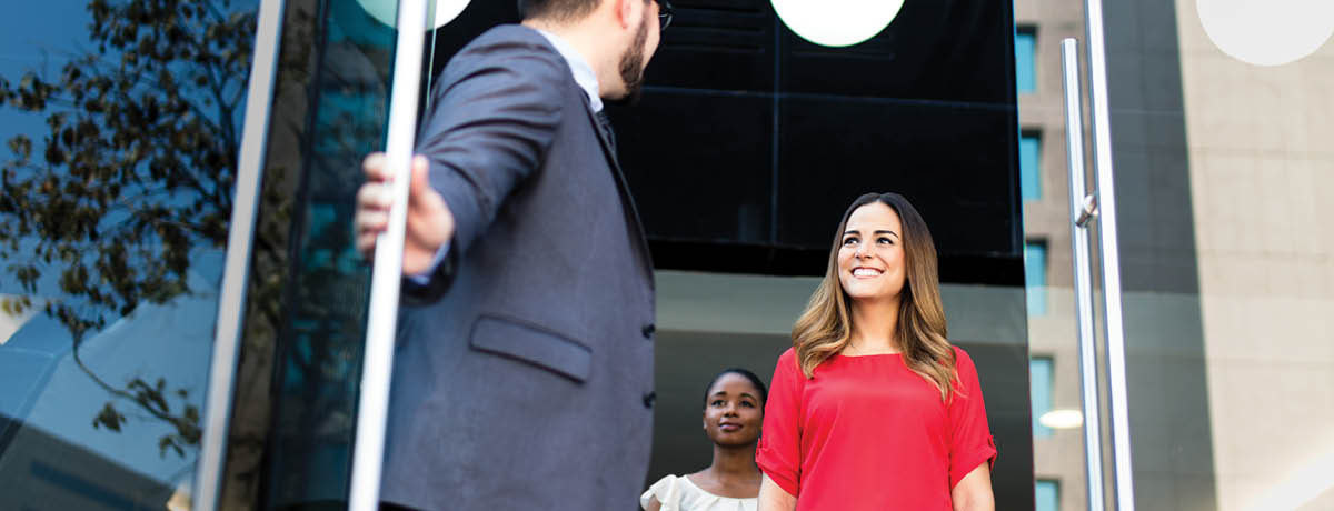 Three people leaving a conference room