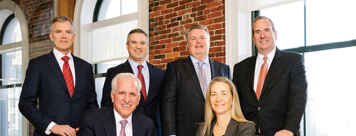 Group of lawyers seated and standing around a table