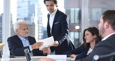 Morelli team reviewing papers at desk with windows behind