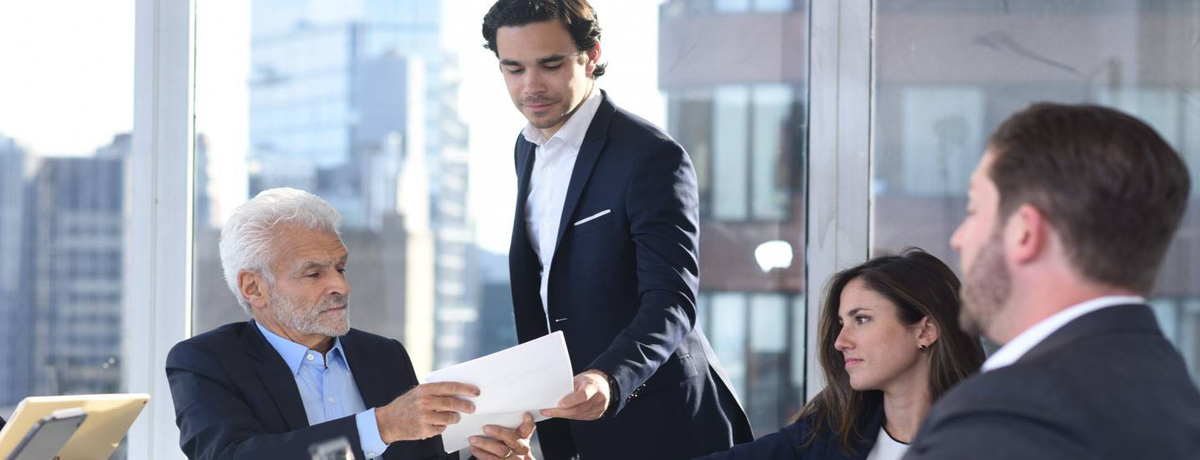 Morelli team reviewing papers at desk with windows behind