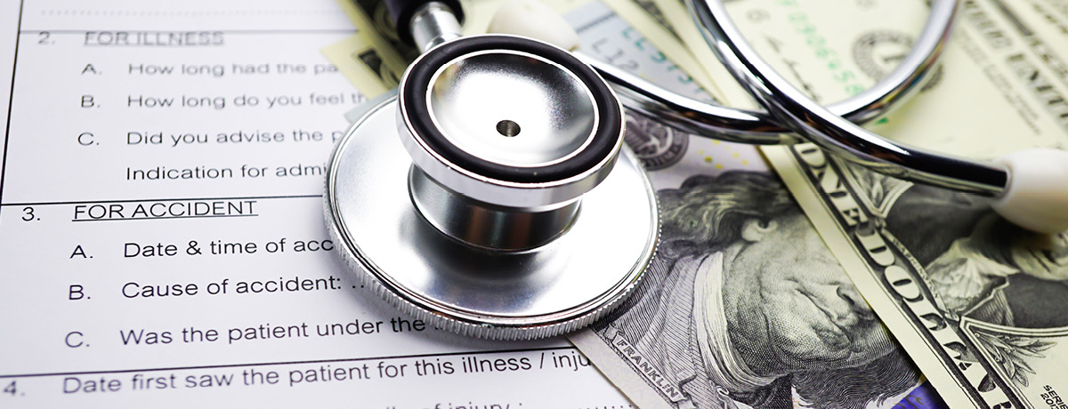 Stethoscope sitting on top of money and medical form