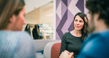 Two women and one man having discussion with purple background