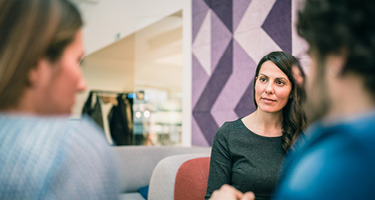 Two women and man having discussion with purple background