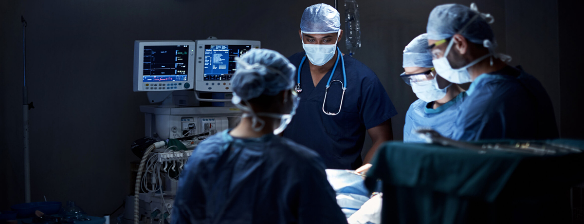 Medical professionals in masks and scrubs in operating room