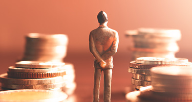 A lone business figure stands between stacks of coins, symbolizing the growing influence of private 