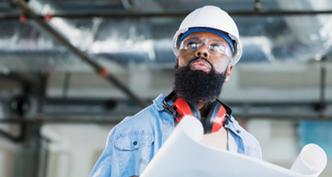 Man wearing hard hat and safety vest while working