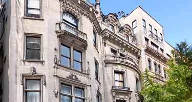 Large brownstone building with blue sky above in New York City