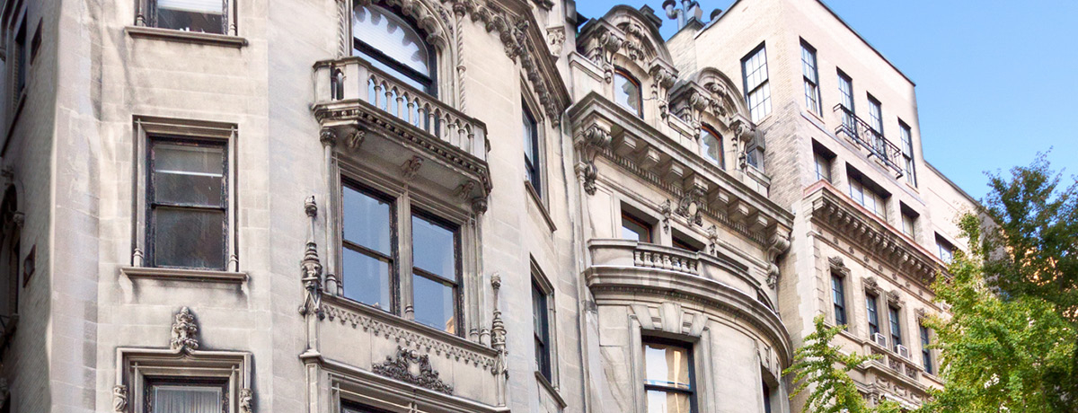 Large brownstone building with blue sky above in New York City