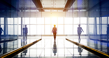 Person walking between glass walls towards window