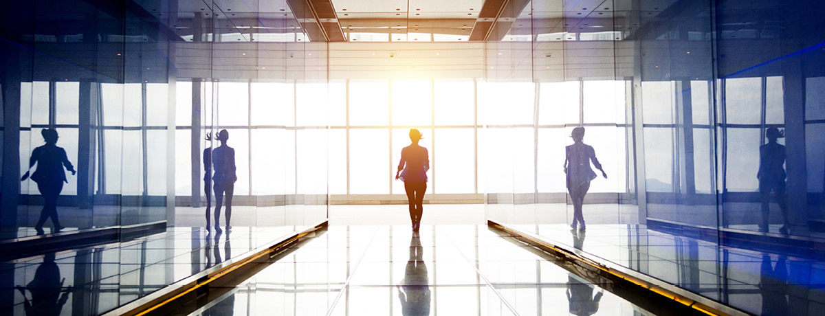 Person walking between glass walls towards window