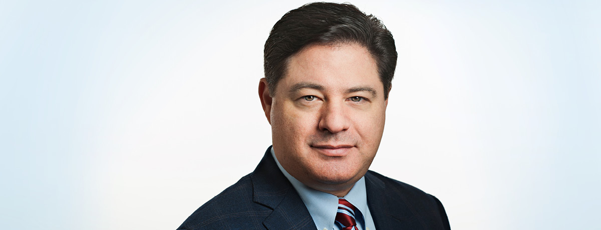 Headshot of male lawyer with brown hair in dark suit