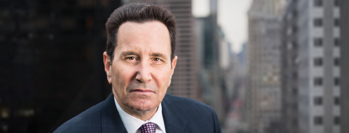 Headshot of attorney with dark brown hair in navy suit