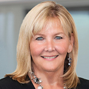 Woman with blond hair and earrings poses for headshot