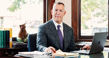 Lawyer sitting at desk with notepad and laptop