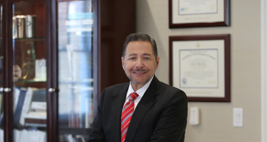 Michael A. DeMayo in a Black Suit and Red Striped Tie
