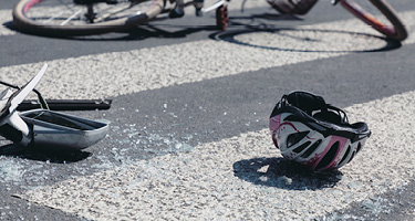Broken bike and helmet on the road