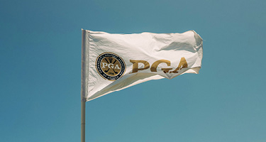 White flag with gold writing against blue sky