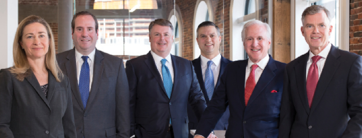 Suited lawyers surround conference table for picture