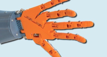 Close-up of an orange 3D-printed hand, illustrating advances.