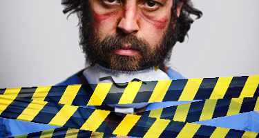 Man with red face paint with a brown beard and caution tape 