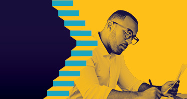 Seated man wearing glasses and looking down