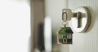 Key with house keychain in door lock