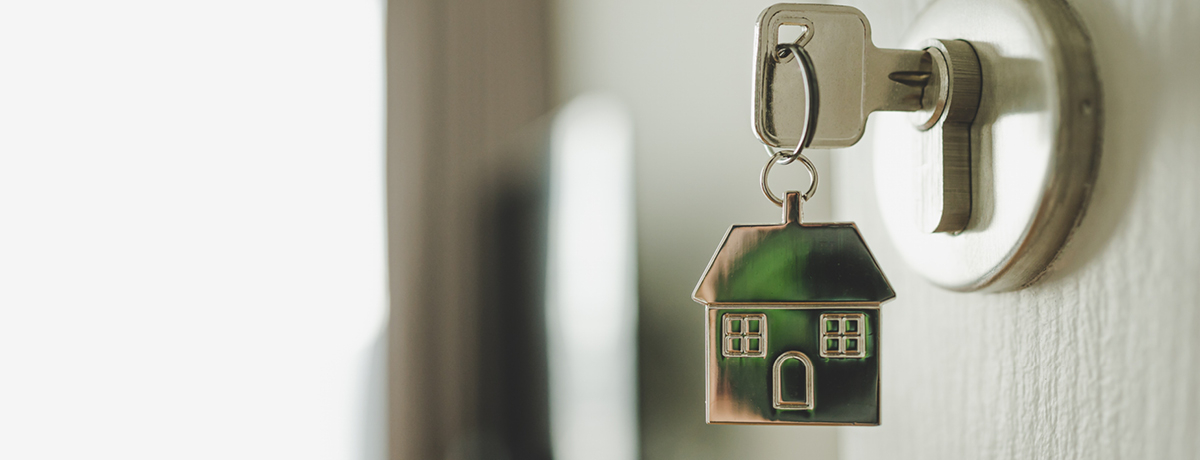 Key with house keychain in door lock