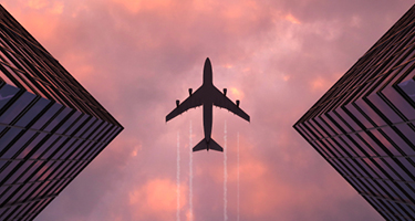 Plane flying between two triangular buildings